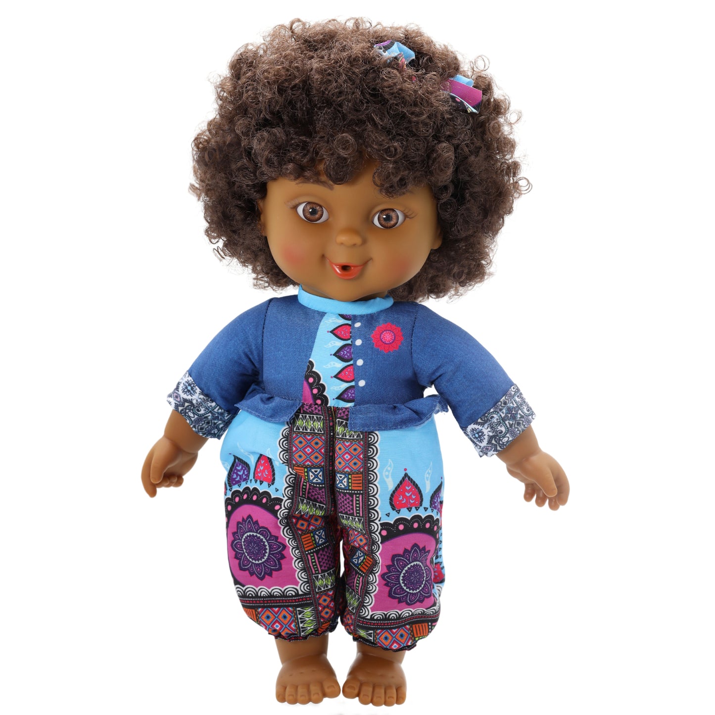A toddler doll with curly brown hair, wearing a blue and multicolored outfit.