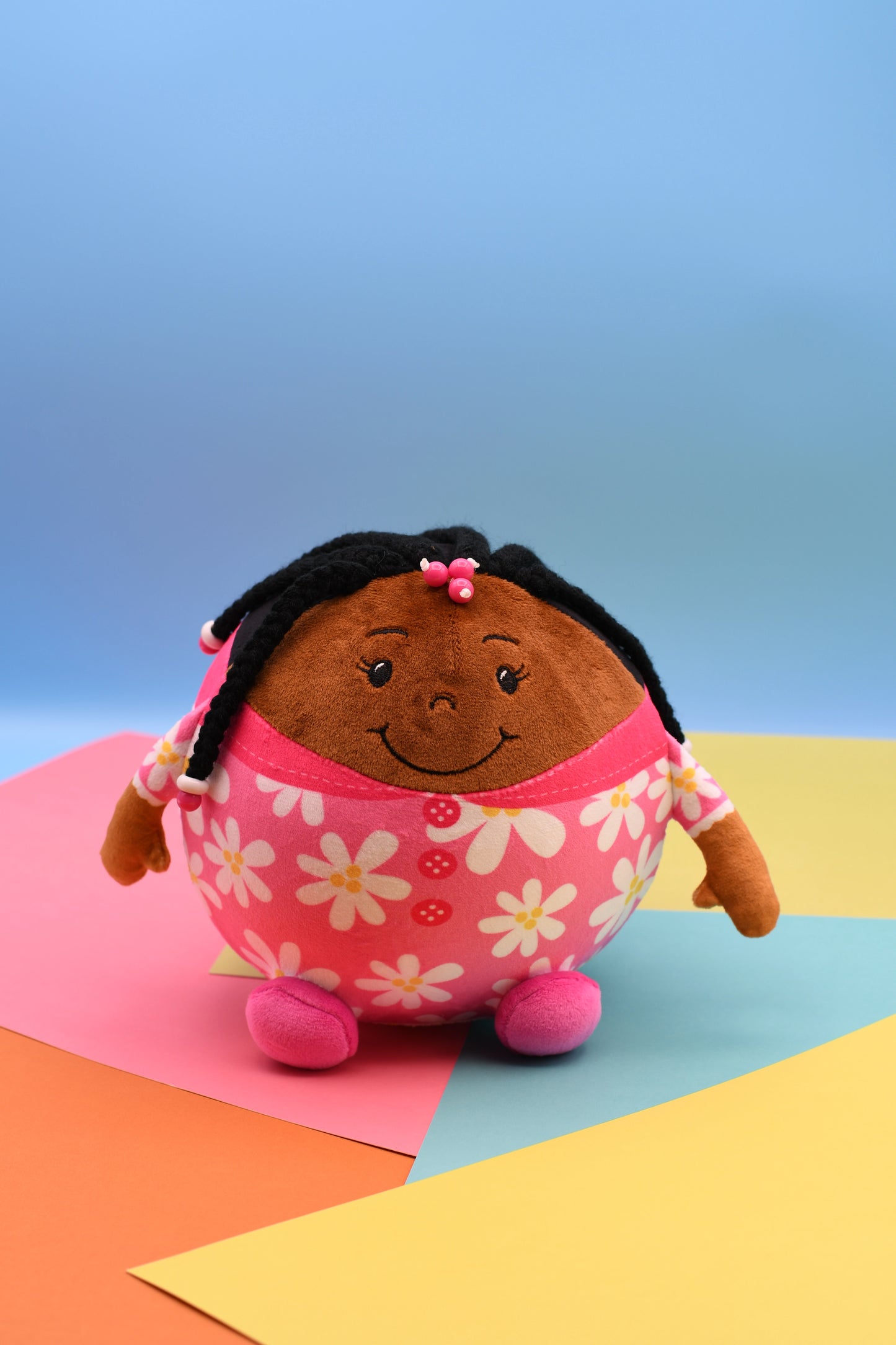 Plush toy with a floral dress on a colorful background