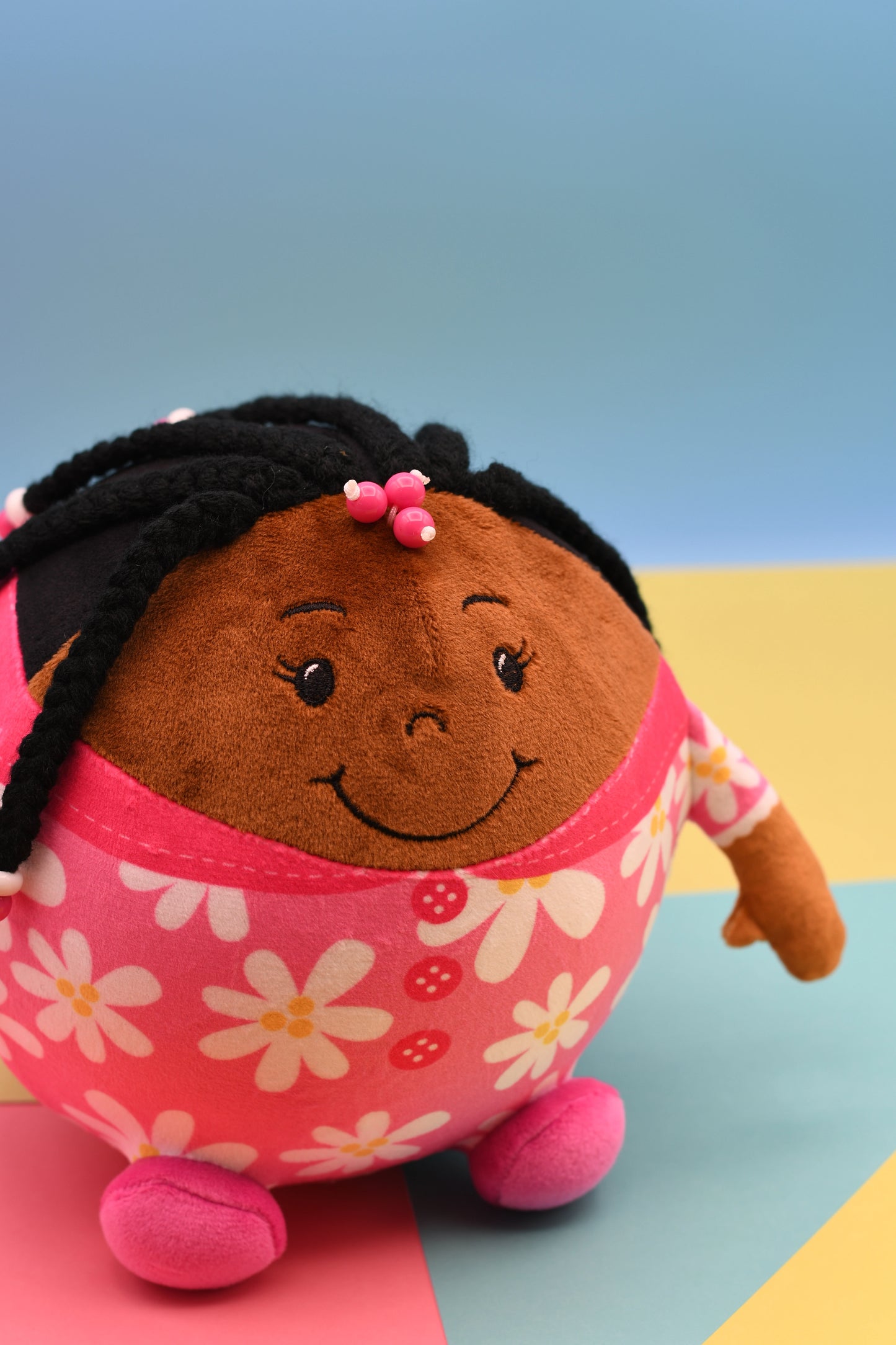 Plush toy with a smiling face on a colorful background