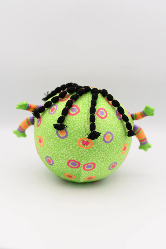 Green ball with colorful patterns and braided hair on a white background