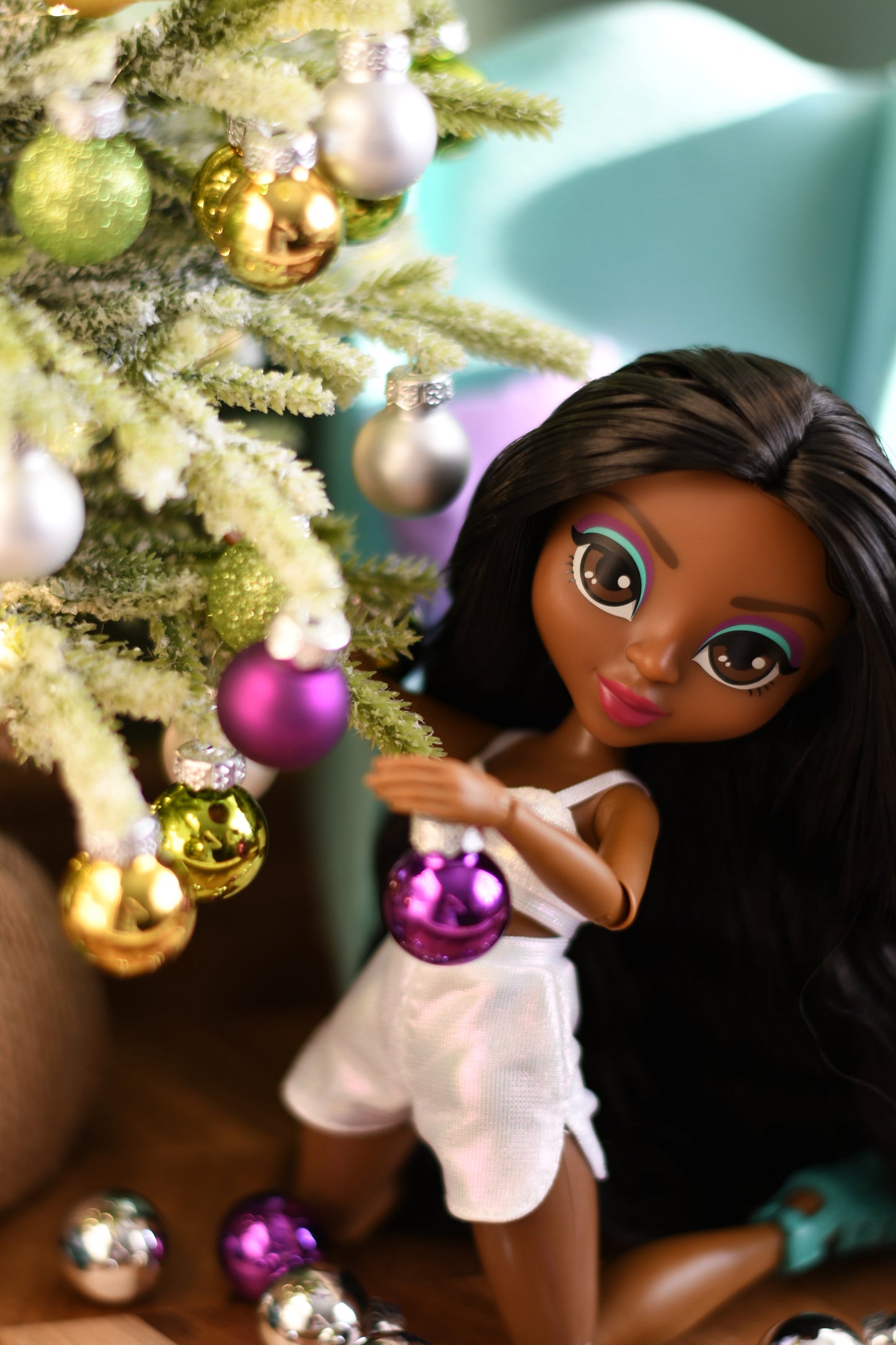 Doll near a Christmas tree with ornaments