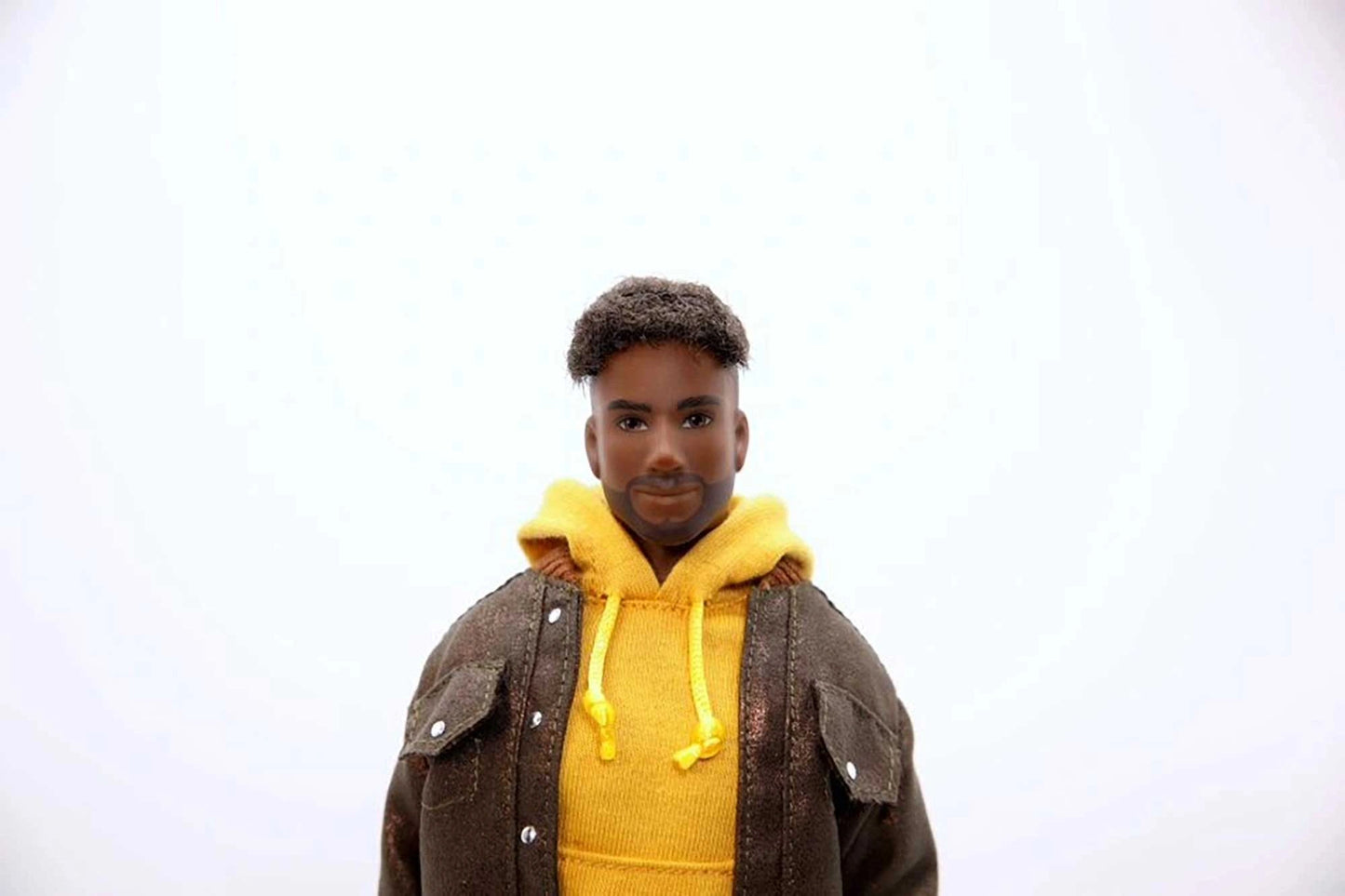 Person wearing a yellow hoodie and brown jacket on a white background