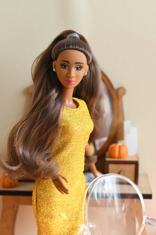 Barbie doll wearing a yellow dress with a blurred background