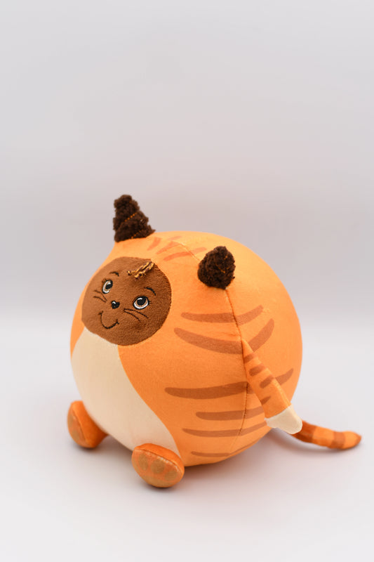 Plush toy resembling a cat with orange fur and brown accents on a light gray background