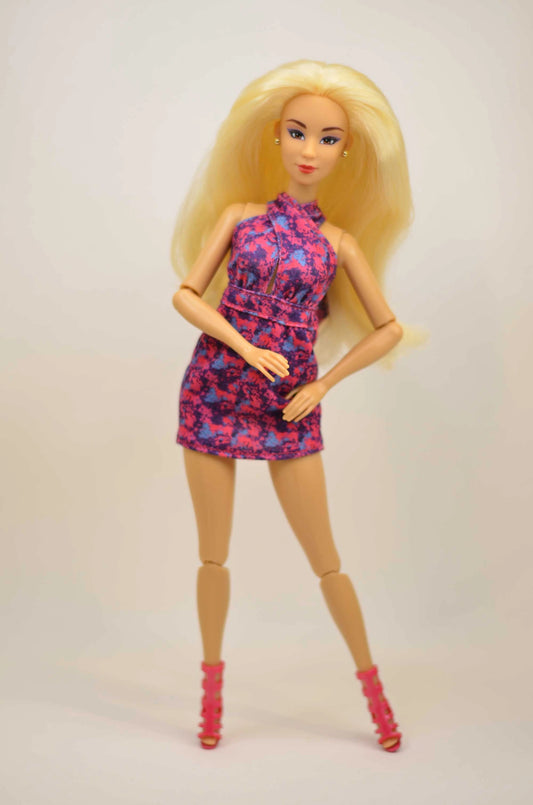 Barbie doll wearing a floral dress on a plain background