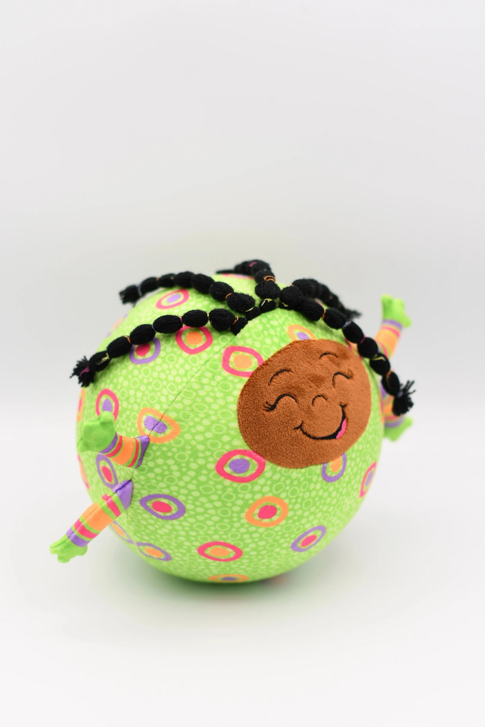 Toy with a smiling face and braided hair on a white background