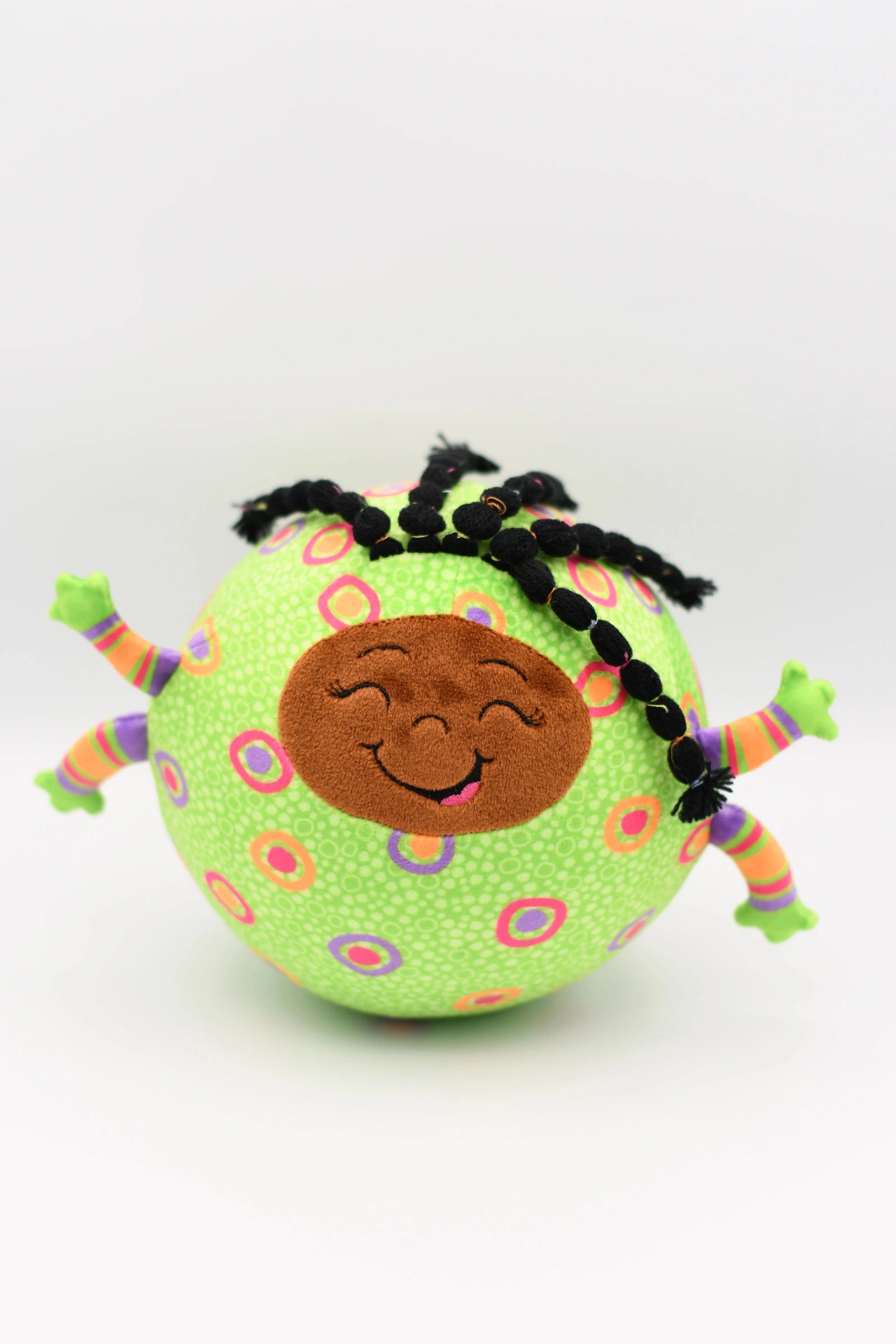 Toy resembling a stylized virus with a smiling face on a white background
