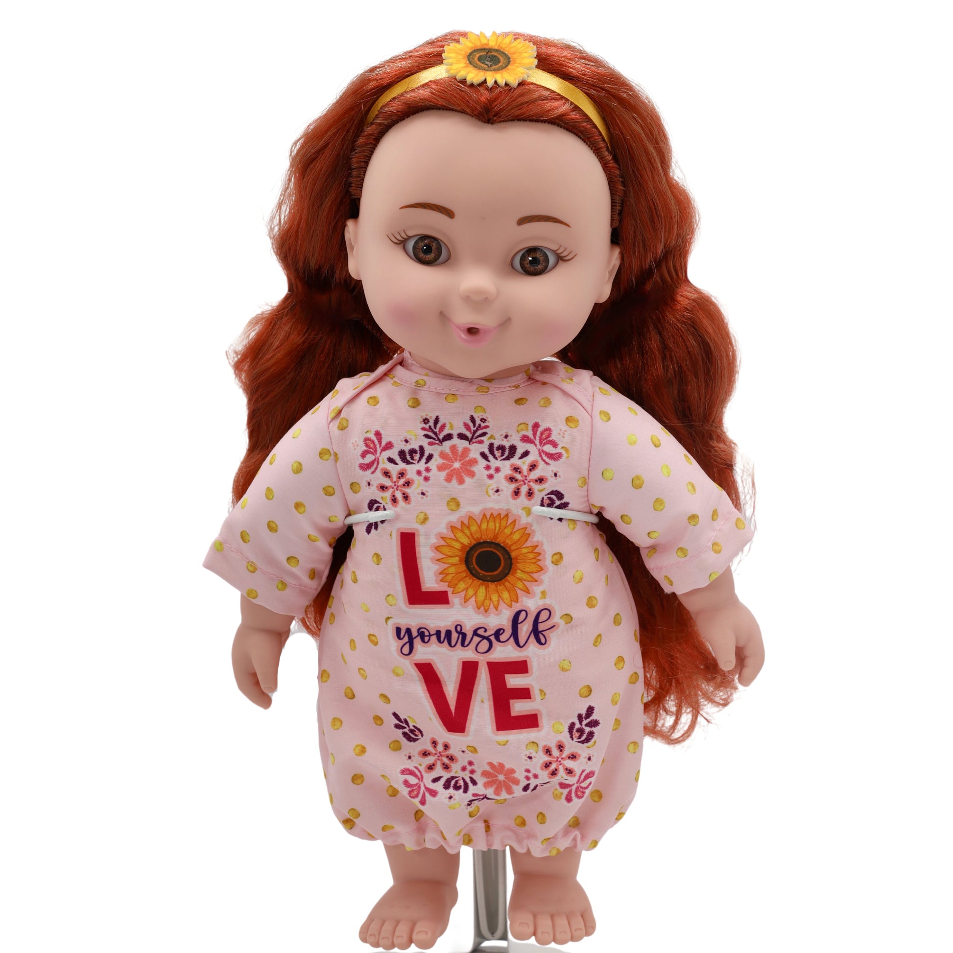 A toddler doll with red hair, wearing a pink floral dress with the text 'LOVE' and a sunflower design.