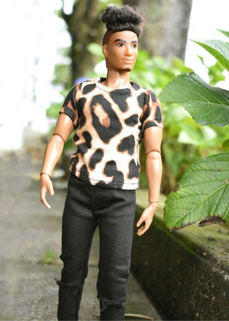 a male doll wearing hole jeans and animal print shirt.
